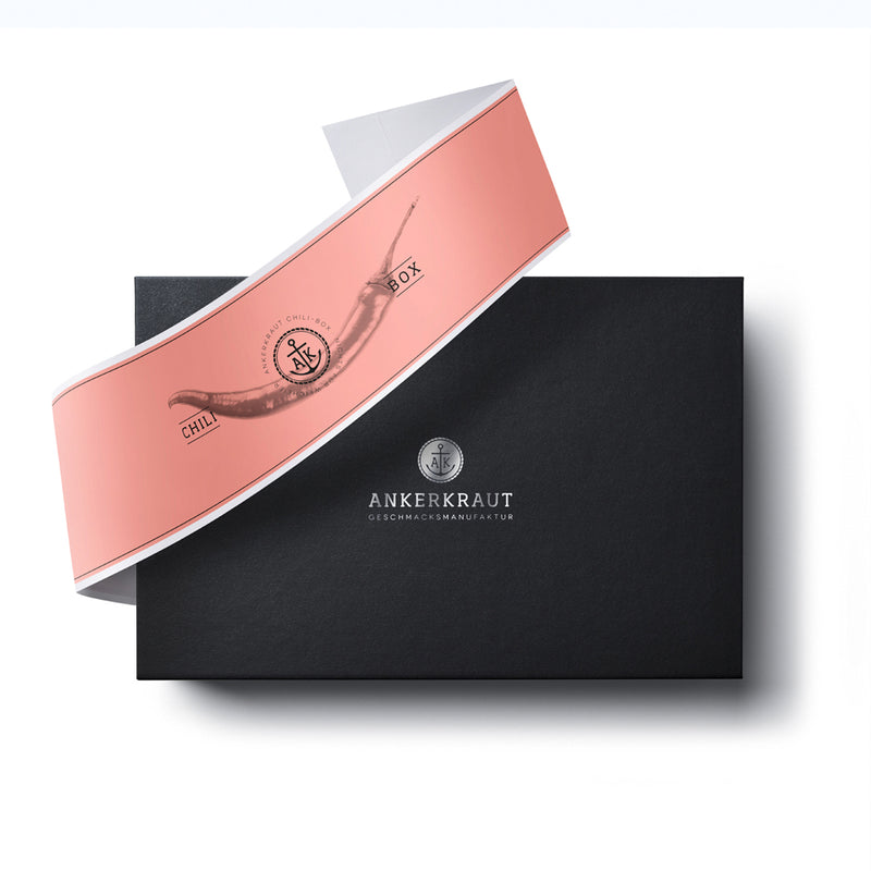 Chili Selection Geschenk-Box aus schwarzem Karton mit diagonaler Banderole.