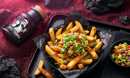 Knusprige Pommes mit Avocado-Topping auf Tablett, daneben Spicetrooper-Gewürz, inszeniert in roter, futuristischer Umgebung.