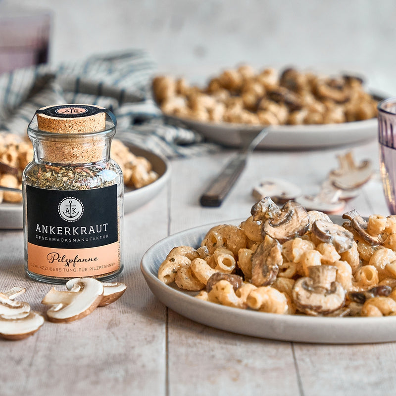 Pilzgewürz neben Pilzpfanne mit Nudeln auf Teller