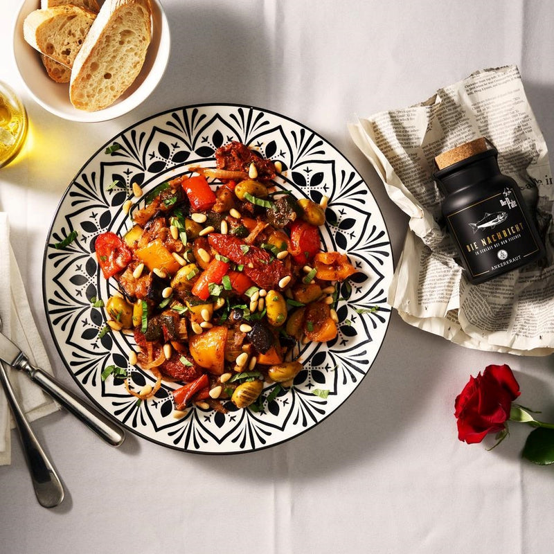 "Die Nachricht" Gewürz neben Carponata auf gedecktem Tisch