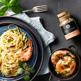 Aglio e Olio Gewürz neben Spaghetti Aglio e Olio auf Teller