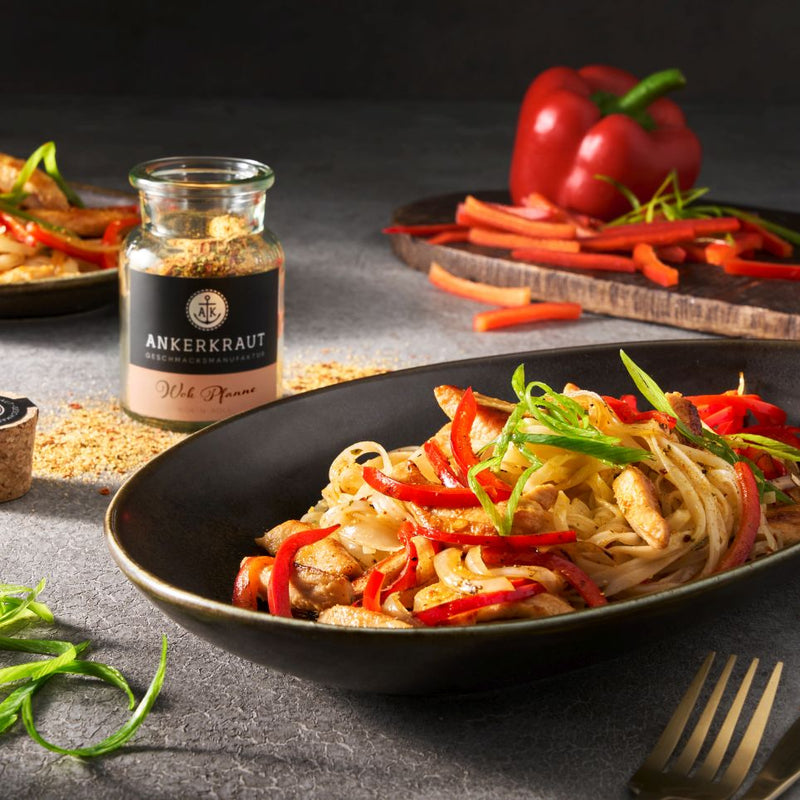 Wok Pfanne mit Hähnchen und Paprika im Teller.