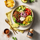 Taco Salat mit Chili Con Carne Gewuerz auf einem tiefen Teller.