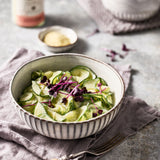 Frischer Gurkensalat in einem Schälchen - dekoriert mit roter Kresse.