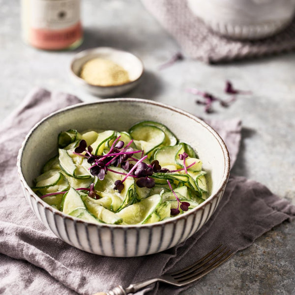 Frischer Gurkensalat in einem Schälchen - dekoriert mit roter Kresse.