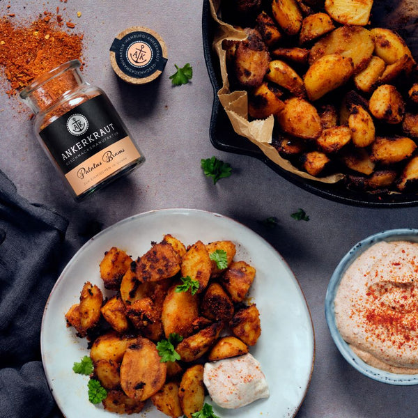 Patatas Bravas mit Dip auf einem Teller.