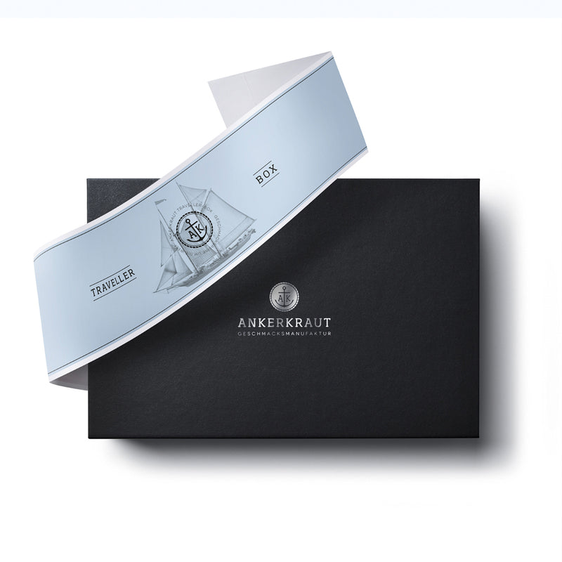 Traveller Plus Geschenk Box aus schwarzem Karton mit diagonaler Banderole.